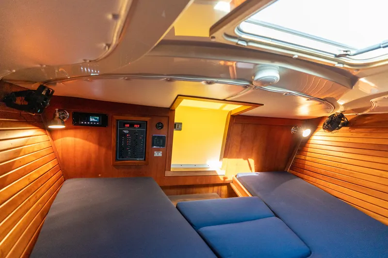 Slide: The Image of Cabin interior of 2003 Hinckley Talaria 29 Runabout with wood paneling and blue cushions. - 39