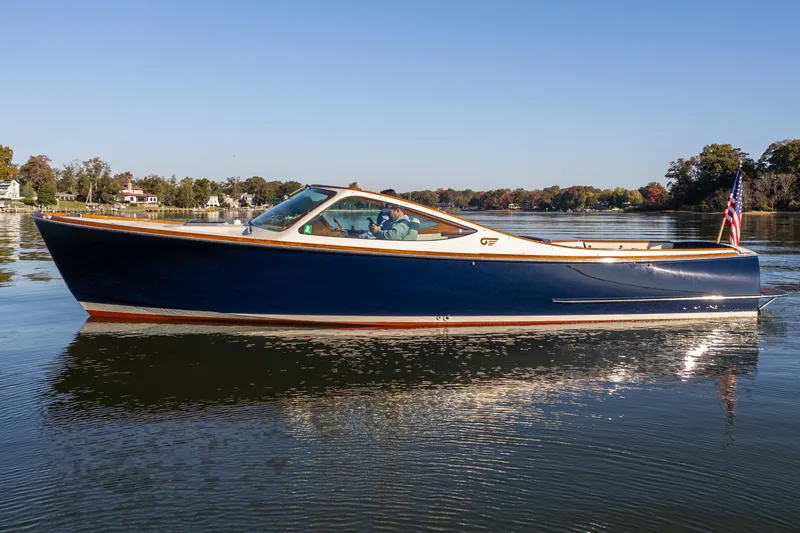 Slide: The Image of 2003 Hinckley Talaria 29 Runabout on calm water, showcasing sleek design and classic elegance. - 4