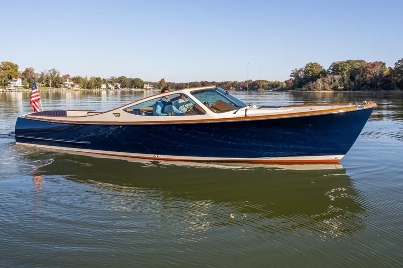 Slide: The Image of 2003 Hinckley Talaria 29 Runabout cruising on a calm lake under a clear blue sky. - 8