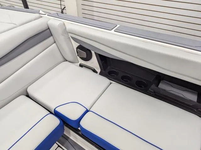 Slide: The Image of 2025 Axis A225 boat interior with white and blue seating and cup holders. - 15