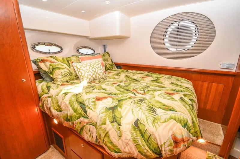 Slide: The Image of Luxurious 2007 Silverton 35 Motor Yacht bedroom with tropical-themed bedding. - 13