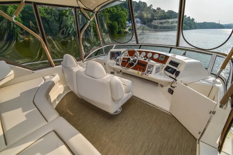 Slide: The Image of 2007 Silverton 35 Motor Yacht interior with helm, white seating, and river view. - 19