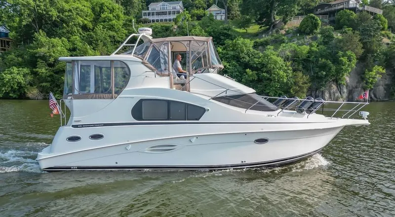 Slide: The Image of 2007 Silverton 35 Motor Yacht cruising on a scenic river with lush greenery. - 3