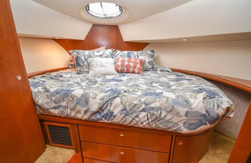 Slide: The Image of Luxurious 2007 Silverton 35 Motor Yacht bedroom with cozy bedding and elegant wood finish. - 8