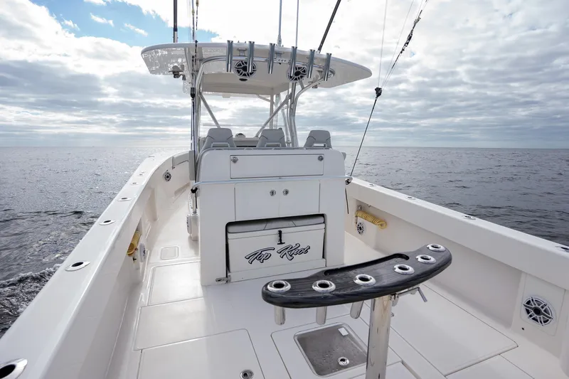 Slide: The Image of 2022 SeaVee 370z boat on open water, featuring spacious deck and fishing rod holders. - 24
