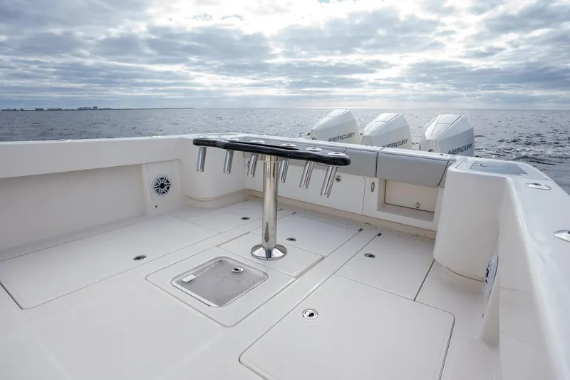 Slide: The Image of 2022 SeaVee 370z boat deck with rod holders, ocean view, and cloudy sky. - 26