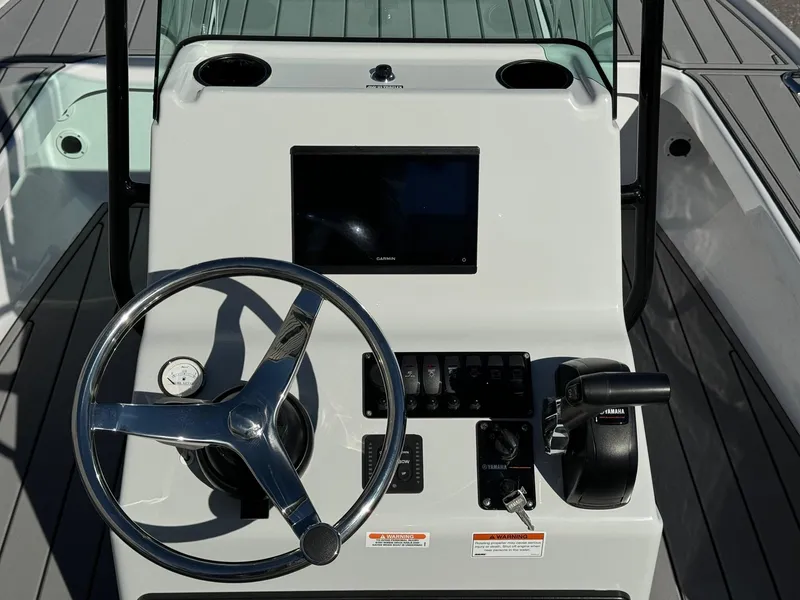 Slide: The Image of Action Craft 17 FLYFISHER 2025 boat console with steering wheel and controls. - 8