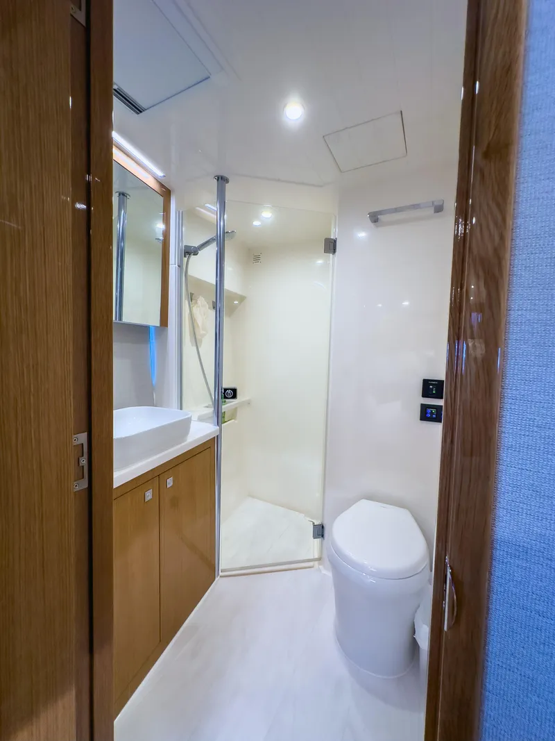 Slide: The Image of 2024 Riviera SMY 46 yacht bathroom with modern fixtures and wooden cabinetry. - 12