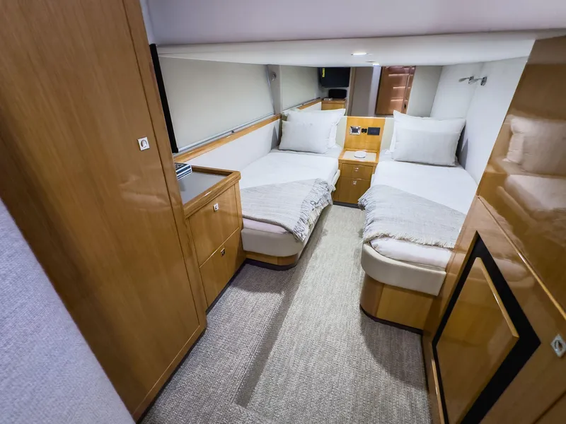Slide: The Image of 2024 Riviera SMY 46 yacht cabin with twin beds, wooden cabinetry, and modern decor. - 16