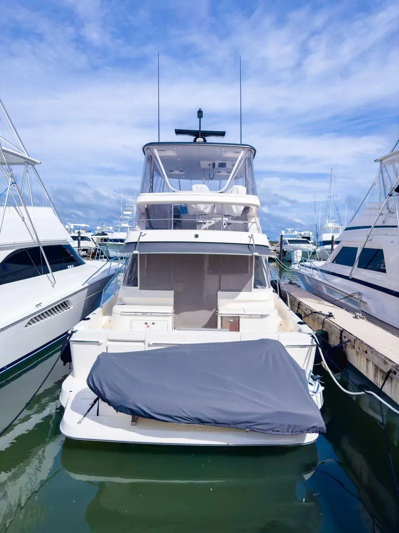 Slide: The Image of 2024 Riviera SMY 46 yacht docked at marina under clear blue sky. - 5