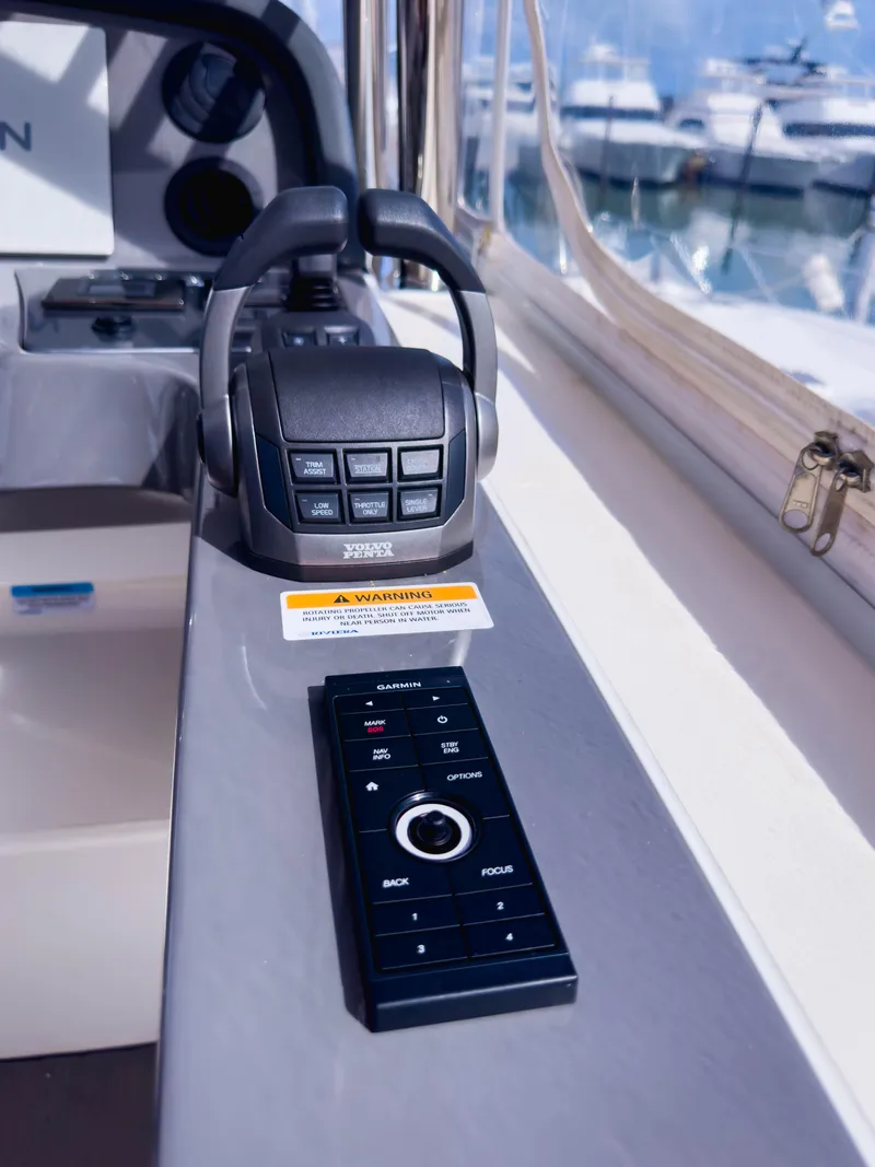 Slide: The Image of 2024 Riviera SMY 46 yacht control panel with remote, docked in marina. - 6