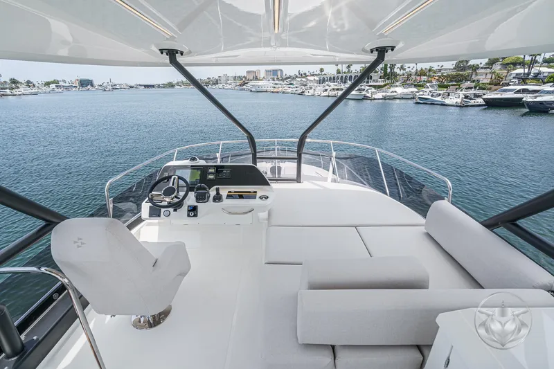 Slide: The Image of Luxurious 2025 Prestige F4.9 yacht interior with helm and seating, overlooking marina. - 15