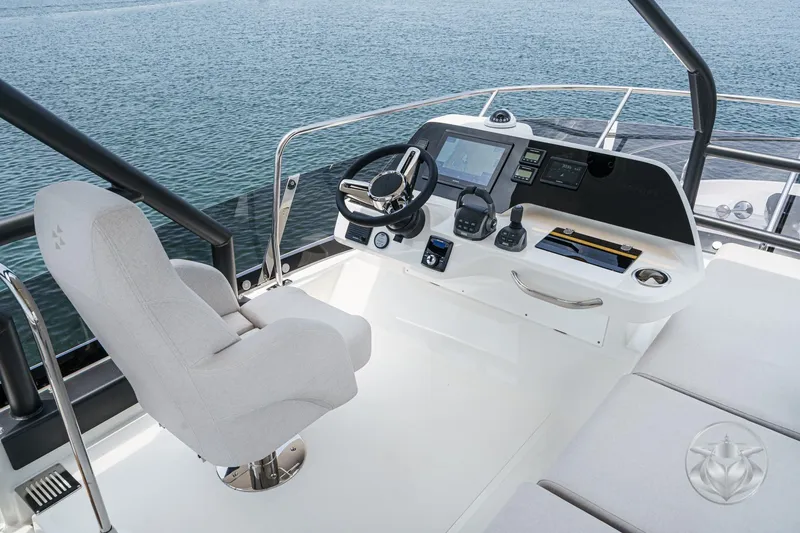 Slide: The Image of Luxury yacht helm with modern controls, Prestige F4.9, 2025 model, overlooking serene water. - 16
