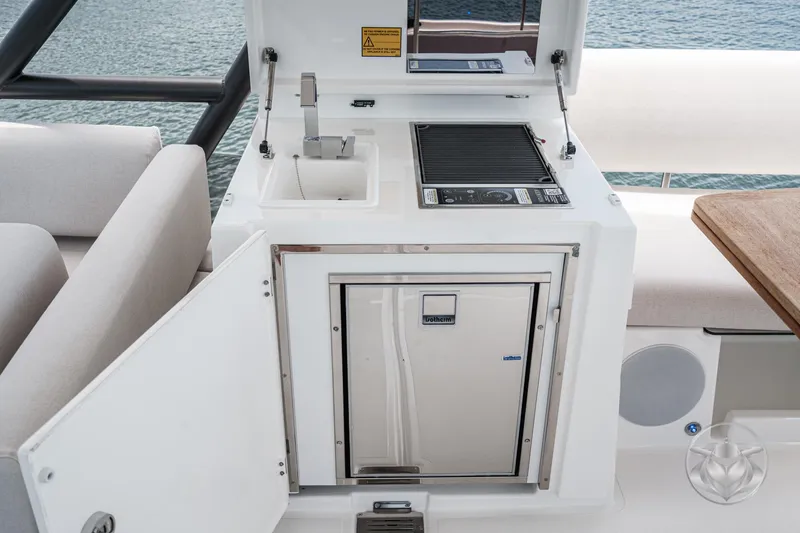 Slide: The Image of Outdoor kitchenette on a 2025 Prestige F4.9 yacht with sink, grill, and mini fridge. - 18