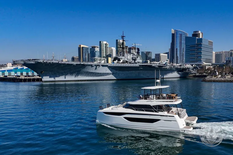 Slide: The Image of Prestige M48 yacht cruising near a large battleship with city skyline in the background, 2026 model. - 17