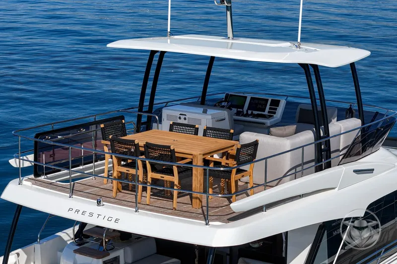 Slide: The Image of Luxury Prestige M48 yacht deck with dining area, 2026 model, on calm blue water. - 20