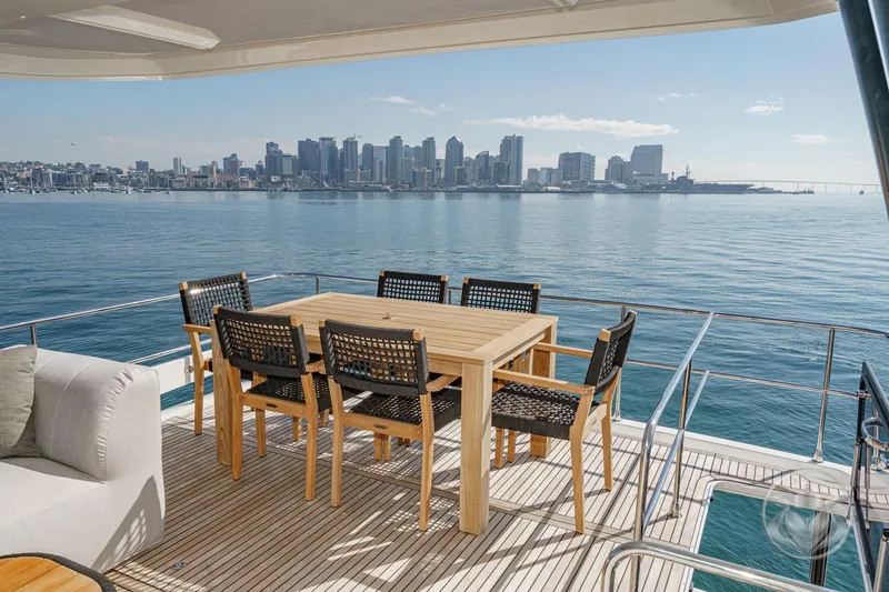 Slide: The Image of Luxury yacht Prestige M48 2026 with city skyline view, featuring elegant outdoor dining area. - 21