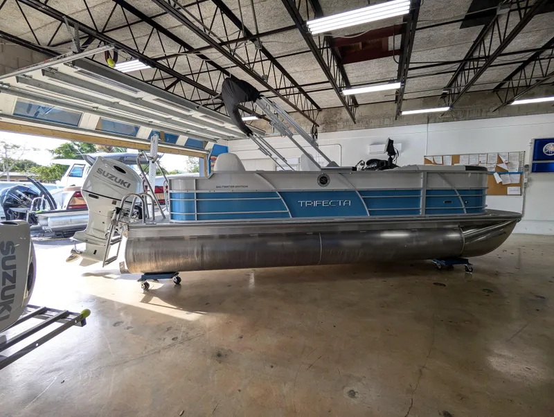 Slide: The Image of 2025 Trifecta CS 22RFC pontoon boat in a garage setting. - 2