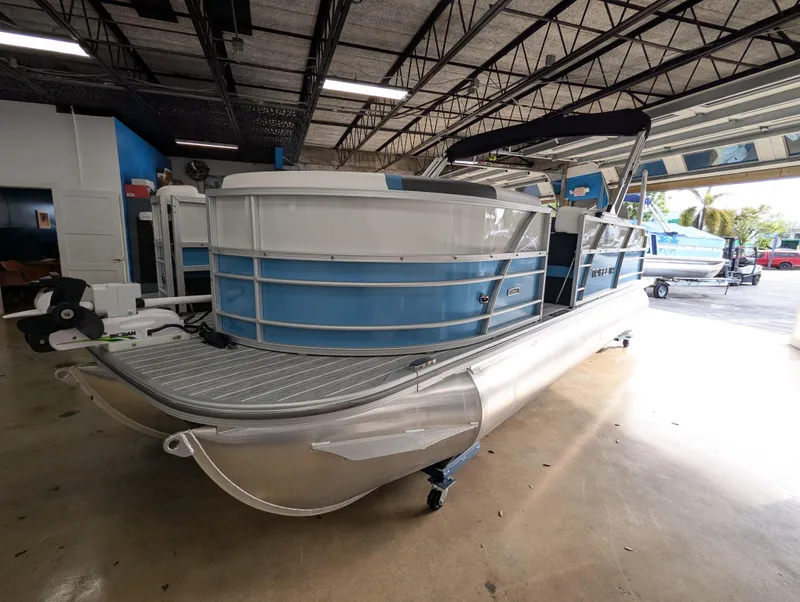 Slide: The Image of 2025 Trifecta CS 22RFC pontoon boat in showroom, featuring sleek blue and white design. - 6