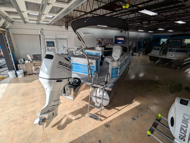 Slide: The Image of 2025 Trifecta CS 22RFC pontoon boat with Suzuki outboard in a garage. - 7
