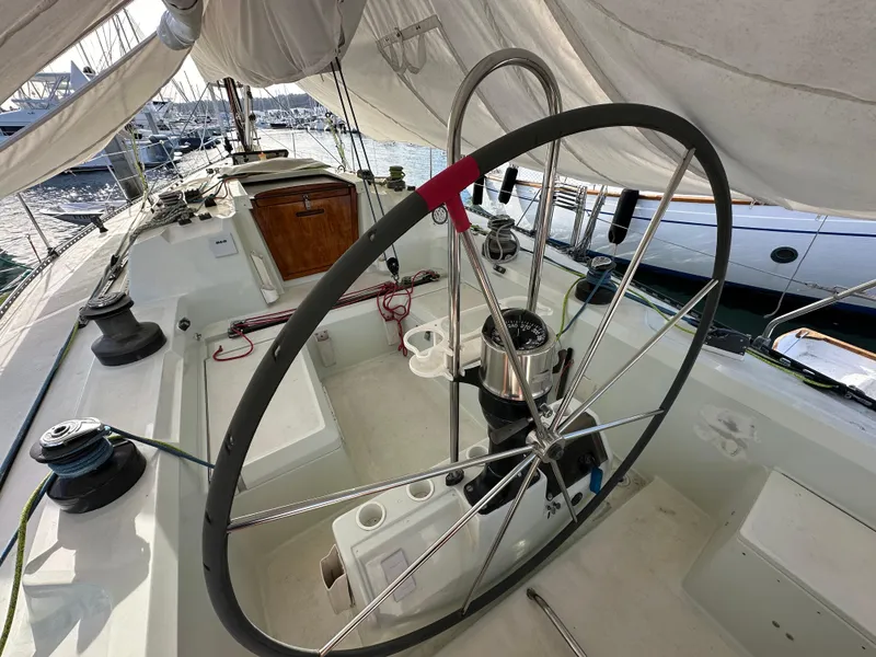 Slide: The Image of 1986 C&C 41 sailboat cockpit with steering wheel and marina view. - 14