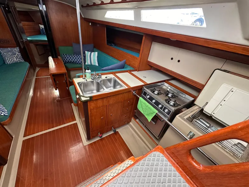 Slide: The Image of Interior of 1986 C&C 41 sailboat with wood finish, kitchen, and seating area. - 15