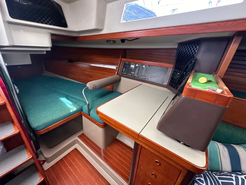 Slide: The Image of Interior of 1986 C&C 41 sailboat with green cushions and wooden accents. - 17
