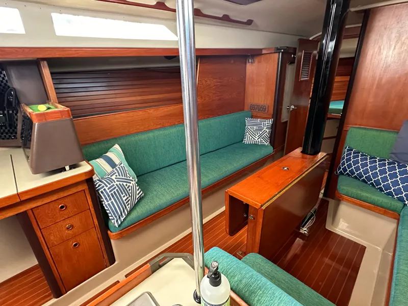 Slide: The Image of Interior of 1986 C&C 41 sailboat with green seating and wooden accents. - 19