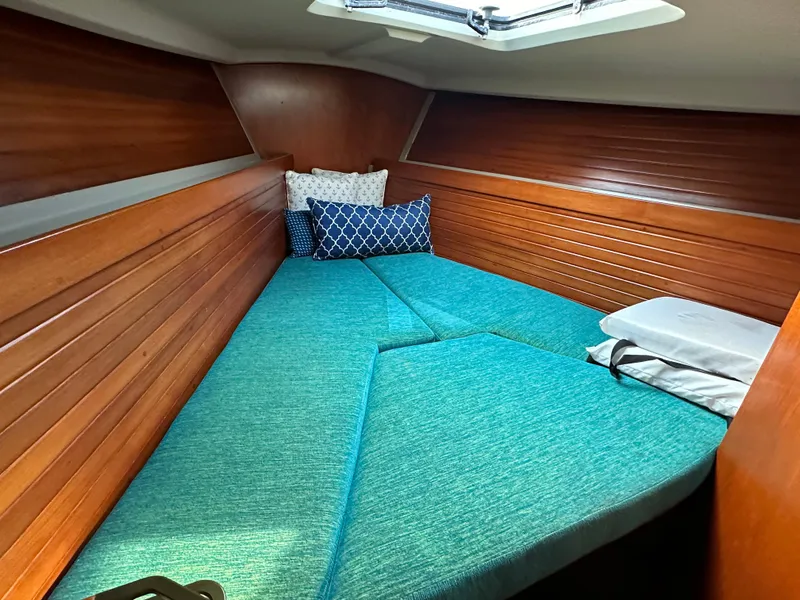 Slide: The Image of Cozy cabin interior of 1986 C&C 41 sailboat with teal cushions and wooden paneling. - 20