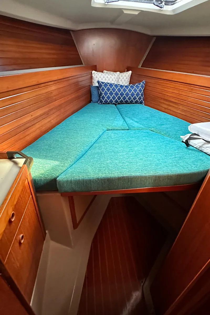 Slide: The Image of 1986 C&C 41 sailboat cabin with teal cushions and wooden interior. - 21