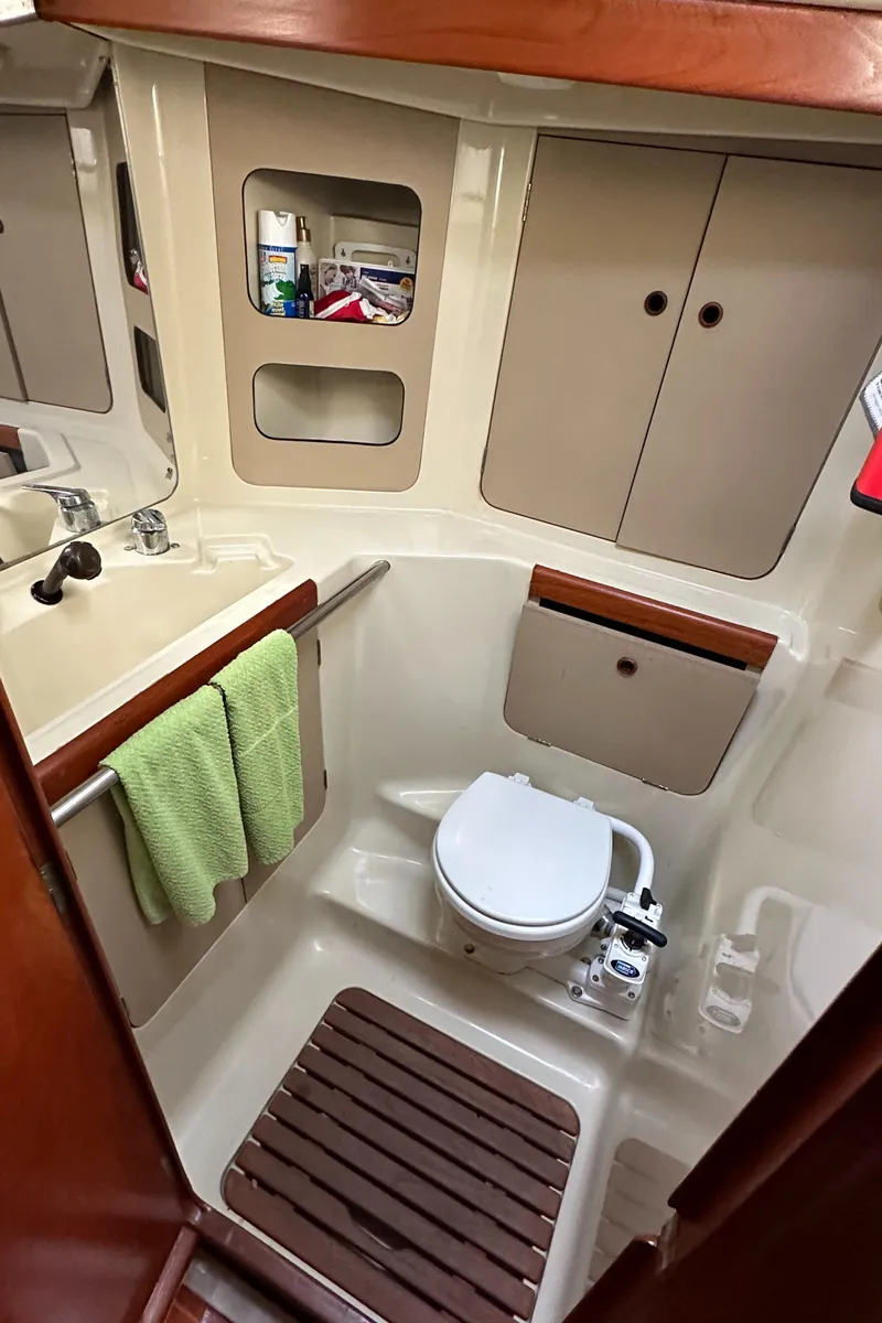 Slide: The Image of 1986 C&C 41 sailboat bathroom with toilet, sink, and storage cabinets. - 22