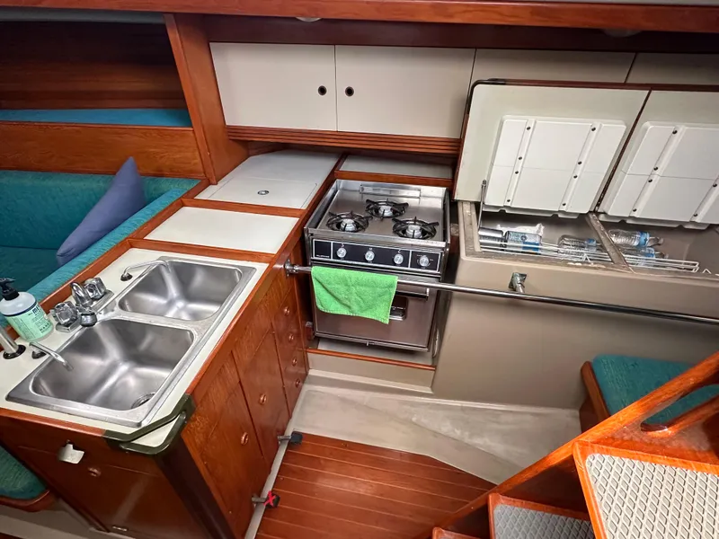 Slide: The Image of 1986 C&C 41 yacht interior kitchen with stove, sink, and wooden cabinetry. - 24