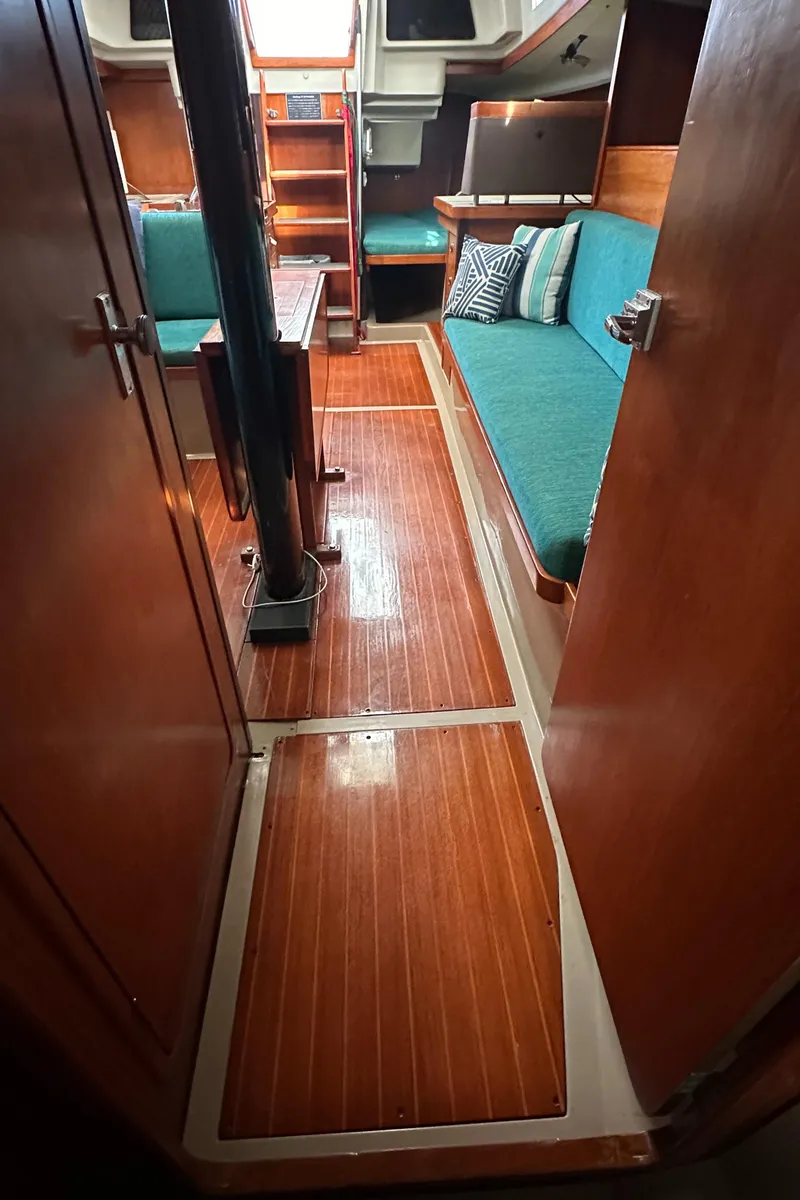 Slide: The Image of Interior of 1986 C&C 41 sailboat with wooden flooring and teal seating. - 25