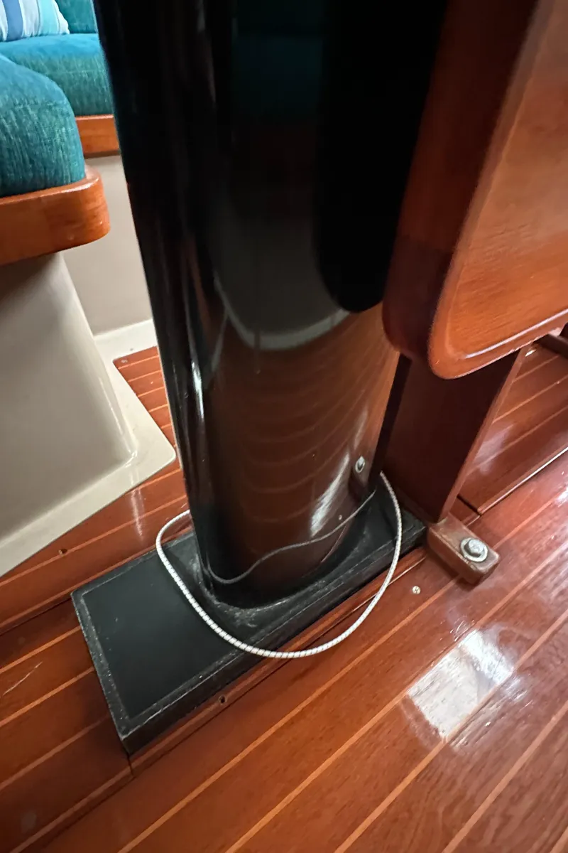 Slide: The Image of Interior of 1986 C&C 41 sailboat, featuring polished wood flooring and mast support. - 26