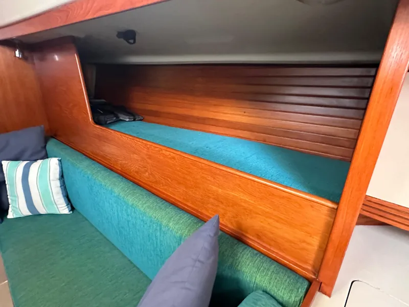 Slide: The Image of 1986 C&C 41 yacht interior with wooden bunk and teal cushions. - 30