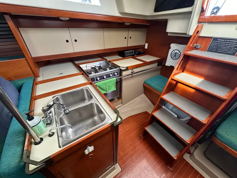 Slide: The Image of 1986 C&C 41 yacht kitchen with dual sink, stove, and wooden cabinetry. - 36