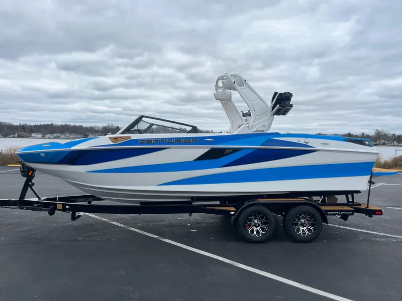 Slide: The Image of 2025 Centurion Fe22 boat with blue and white design on a trailer. - 13