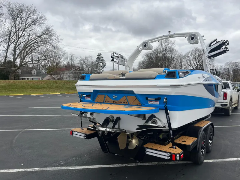 Slide: The Image of 2025 Centurion Fe22 boat on trailer in parking lot, overcast sky. - 2
