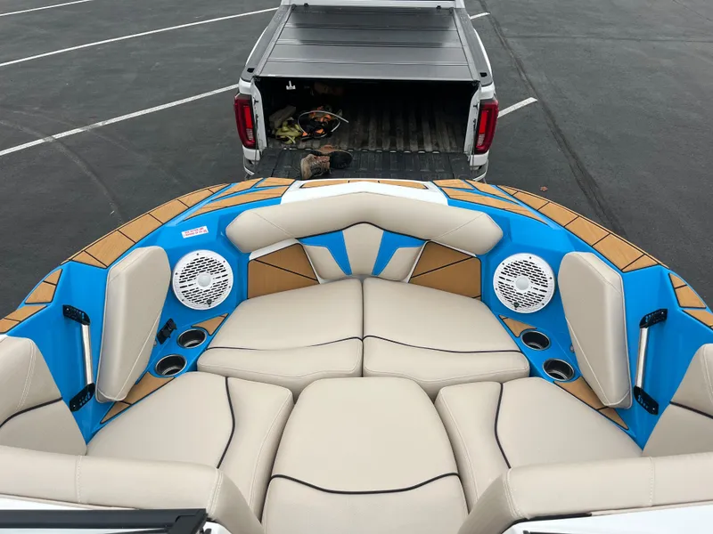 Slide: The Image of 2025 Centurion Fe22 boat interior with beige seats and blue accents, parked near a truck. - 4