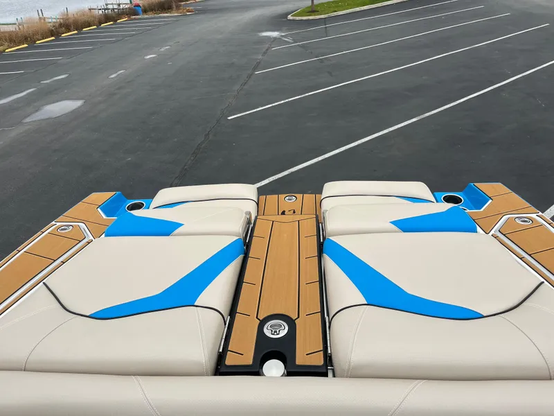 Slide: The Image of 2025 Centurion Fe22 boat with beige and blue seating in a parking lot. - 8