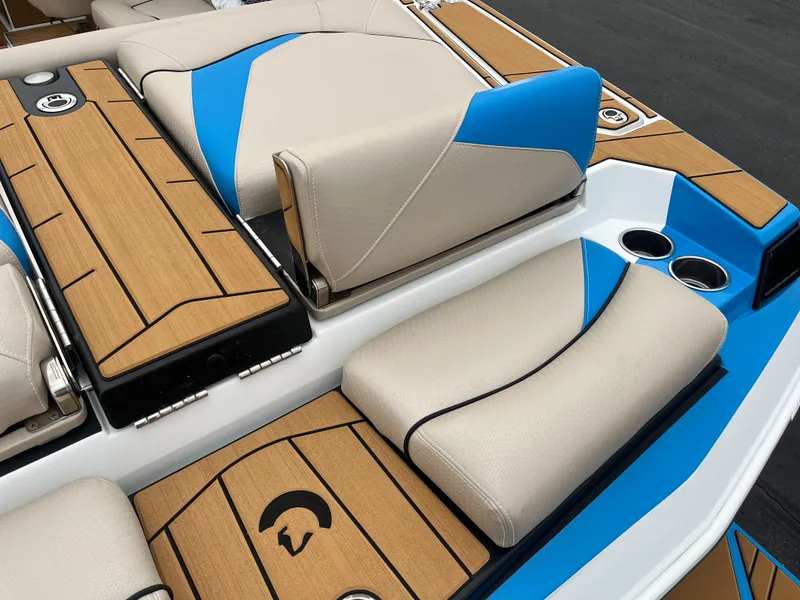 Slide: The Image of 2025 Centurion Fe22 boat interior with beige and blue seating, wood accents, and cup holders. - 9