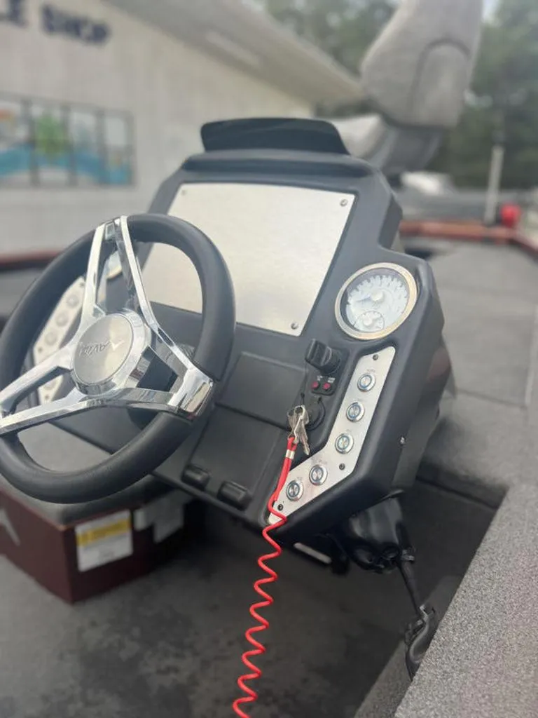 Slide: The Image of 2023 Avid 18XB boat dashboard with steering wheel and control panel. - 14