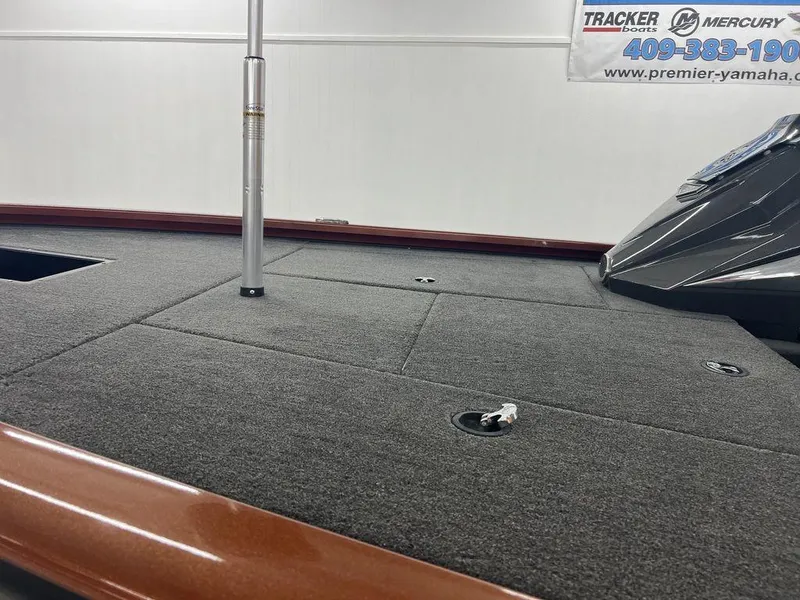 Slide: The Image of 2023 Avid 18XB boat deck with carpeted surface and fishing pole holder. - 15