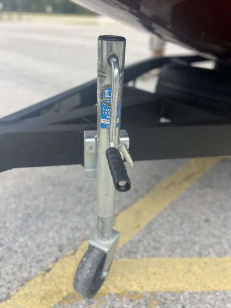 Slide: The Image of Trailer jack on Avid 18XB boat trailer, 2023 model, parked on asphalt. - 26