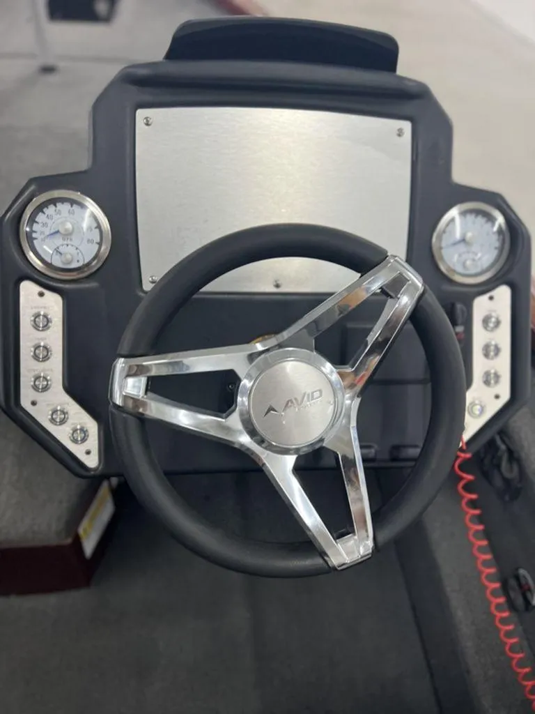 Slide: The Image of Steering wheel of 2023 Avid 18XB boat with dashboard gauges. - 27