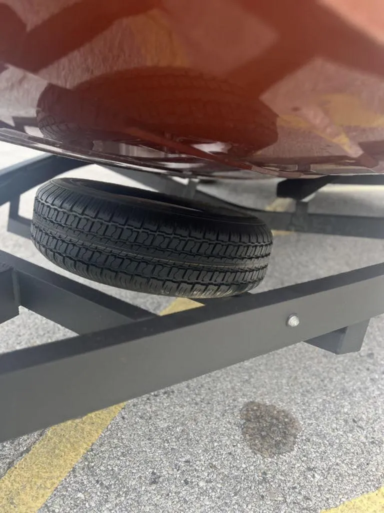 Slide: The Image of 2023 Avid 18XB boat trailer with spare tire on asphalt. - 28