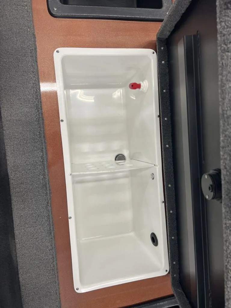 Slide: The Image of Avid 18XB 2023 boat storage compartment with white interior and red valve. - 33