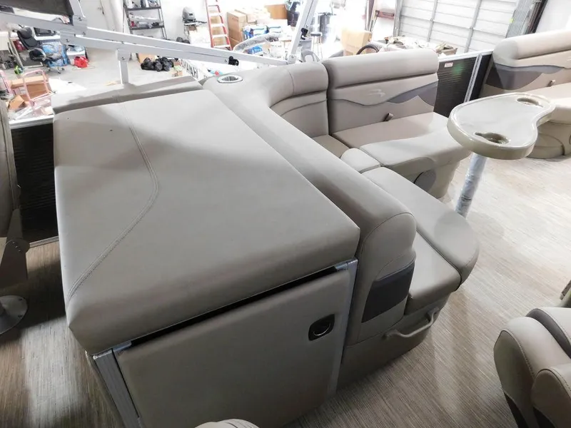 Slide: The Image of 2023 Bennington 20SSSP pontoon boat interior with beige seating and table. - 14