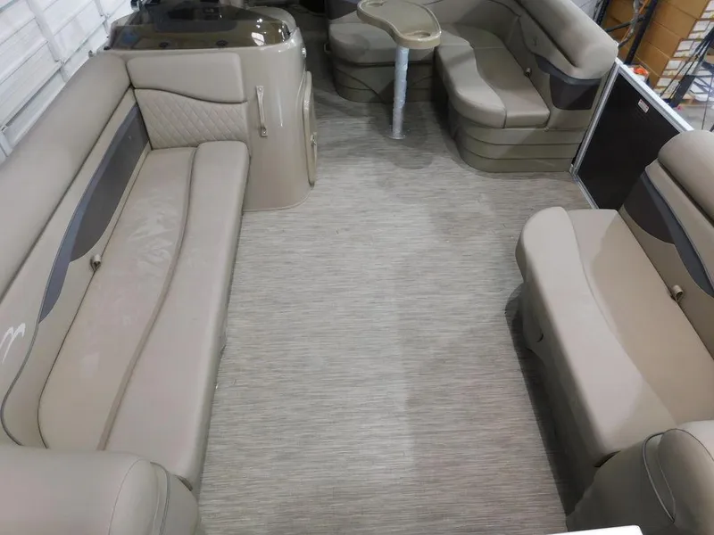 Slide: The Image of 2023 Bennington 20SSSP pontoon boat interior with beige seating and table. - 9