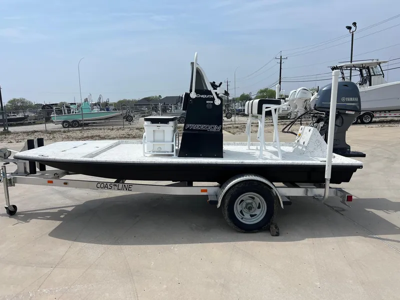 Slide: The Image of 2024 Freedom 14 Chiquita boat on trailer with Yamaha engine, parked outdoors. - 13